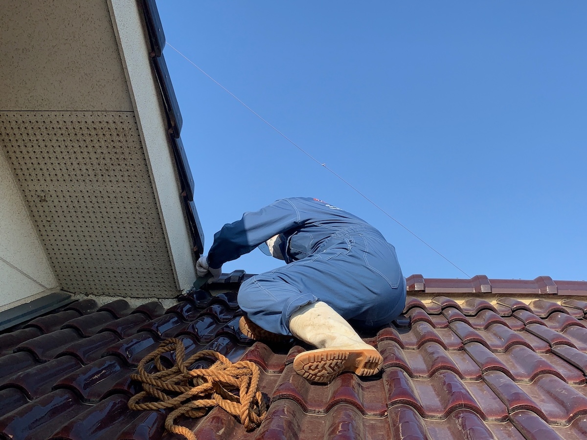 屋根の雨漏り工事を行う男性