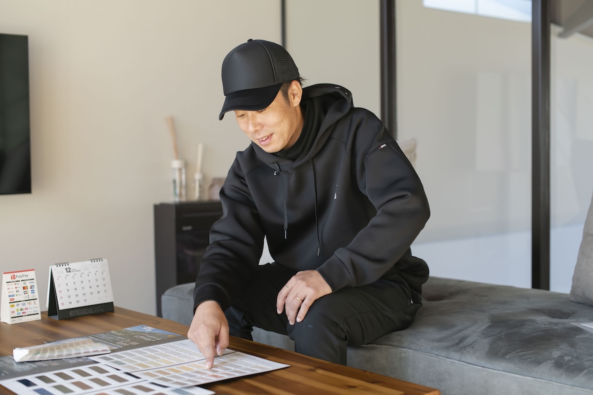 外壁の色について説明する男性職人の写真