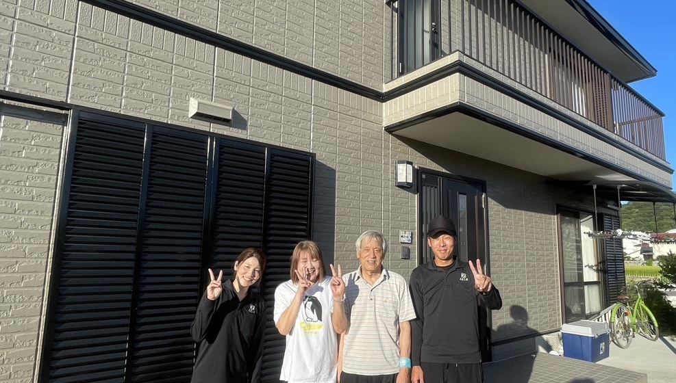 施工後に職人とお客様の４名で笑顔でポーズを取る写真